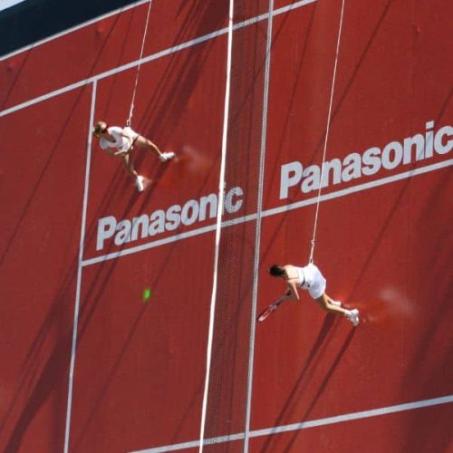 Vertical Sports Tennisspieler hängen an Seilen an einer Gebäudefassade